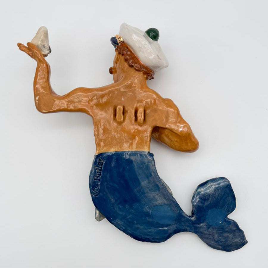 Mermaid figurine with a blue tail and tan upper body on a white background