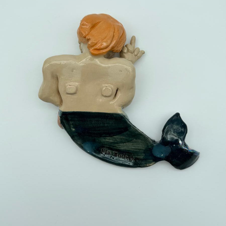 Mermaid figurine with orange hair and black tail on a light gray background
