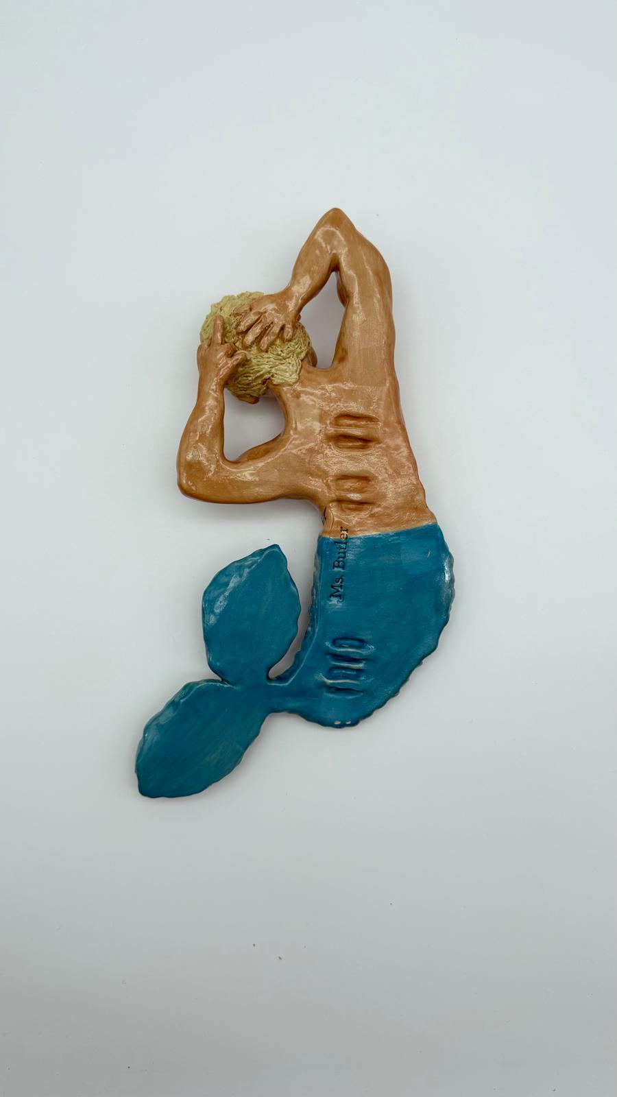 Decorative mermaid figurine with a blue tail and brown upper body on a white background