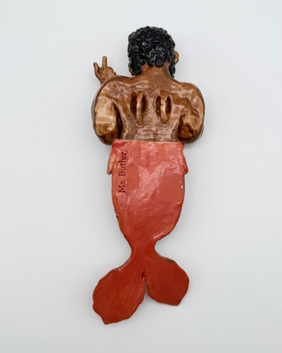 Decorative wall hanging of a mermaid with a human-like top half on a white background